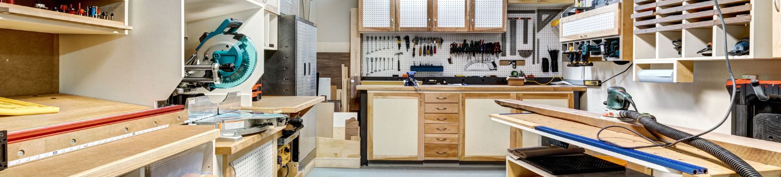 Spacious garage workshop in Mound, MN, featuring built-in cabinets, organized tool storage, wood workbenches, and overhead lighting for a clean, functional workspace.